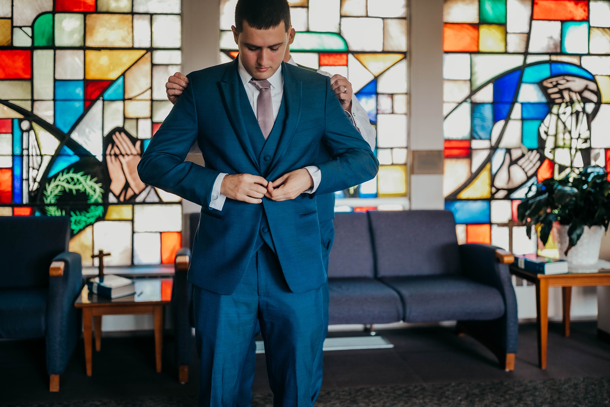 groom prepares for Ohio wedding by stained glass