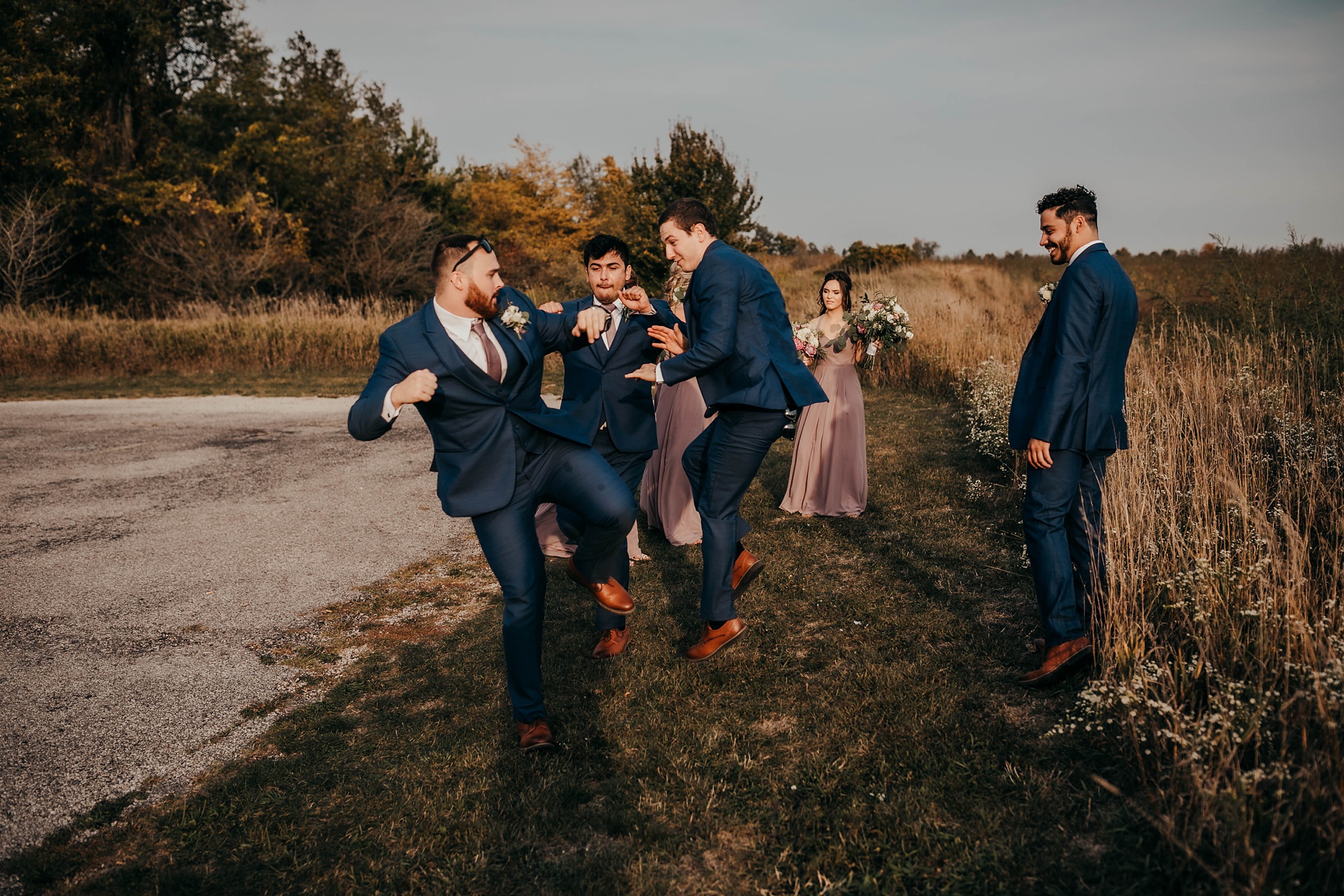 groomsmen goof off in Ohio field during wedding photos
