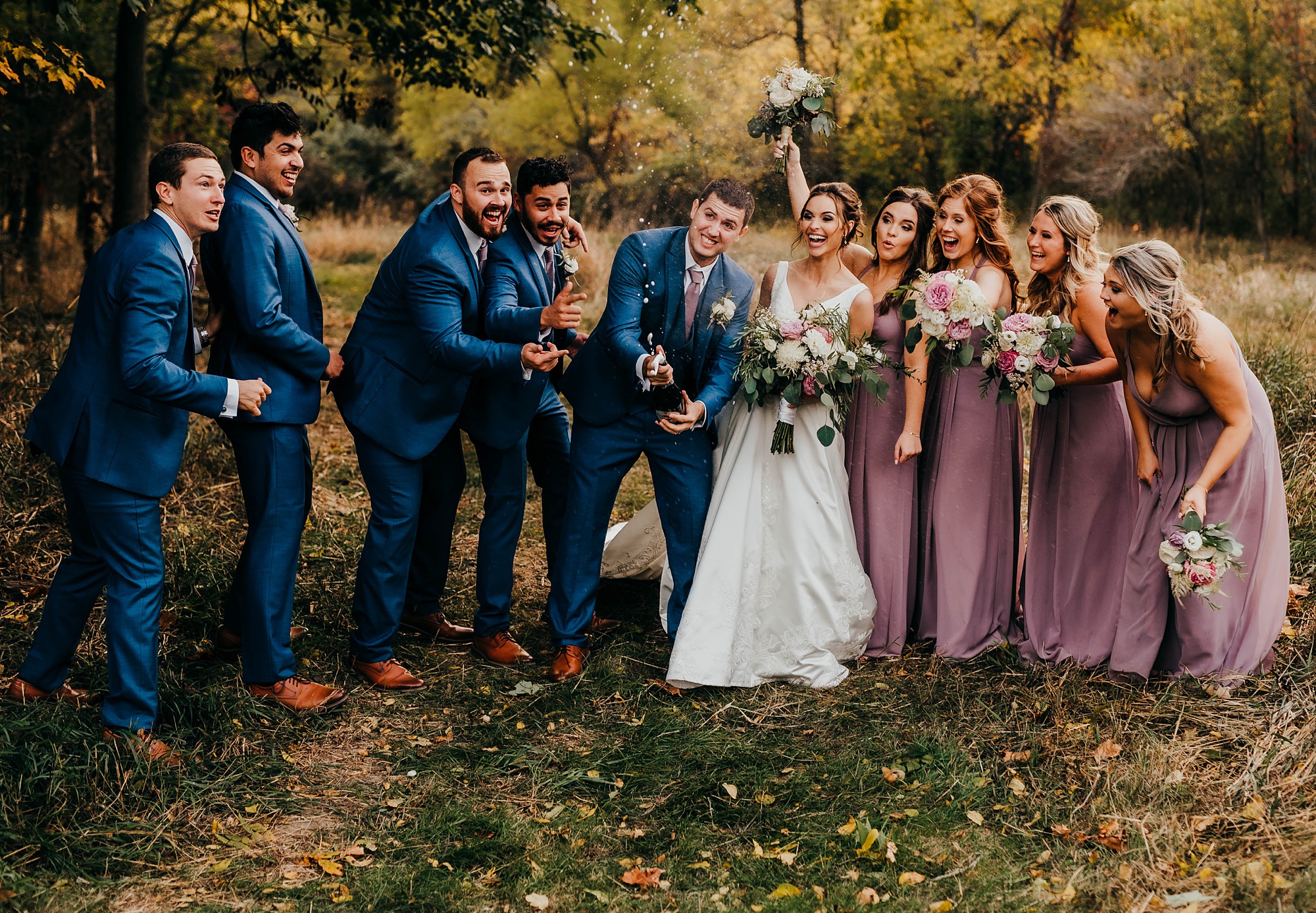 groom pops champagne with bridal party
