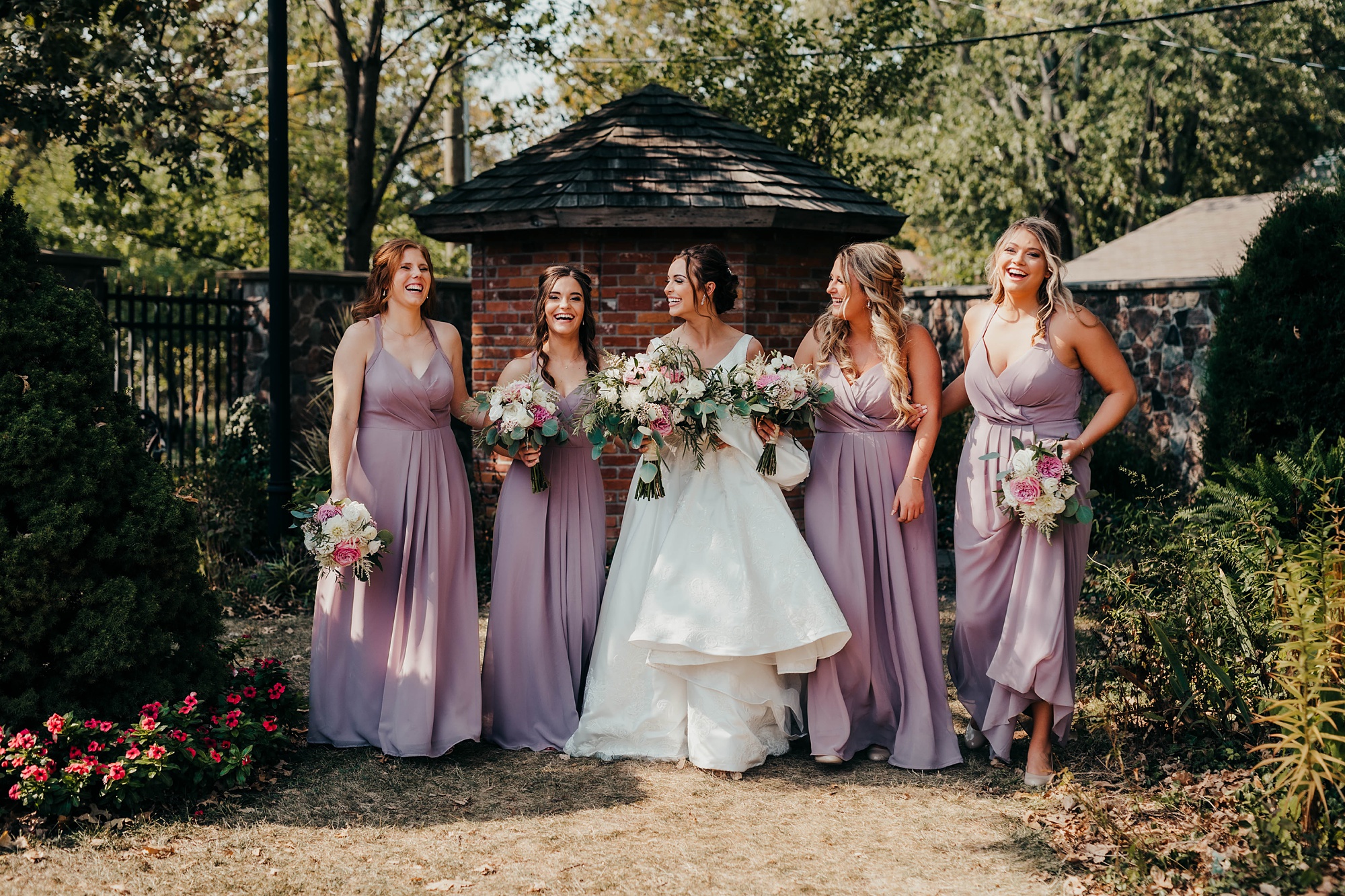 bridesmaids walk with bride and groom on elegant fall wedding day