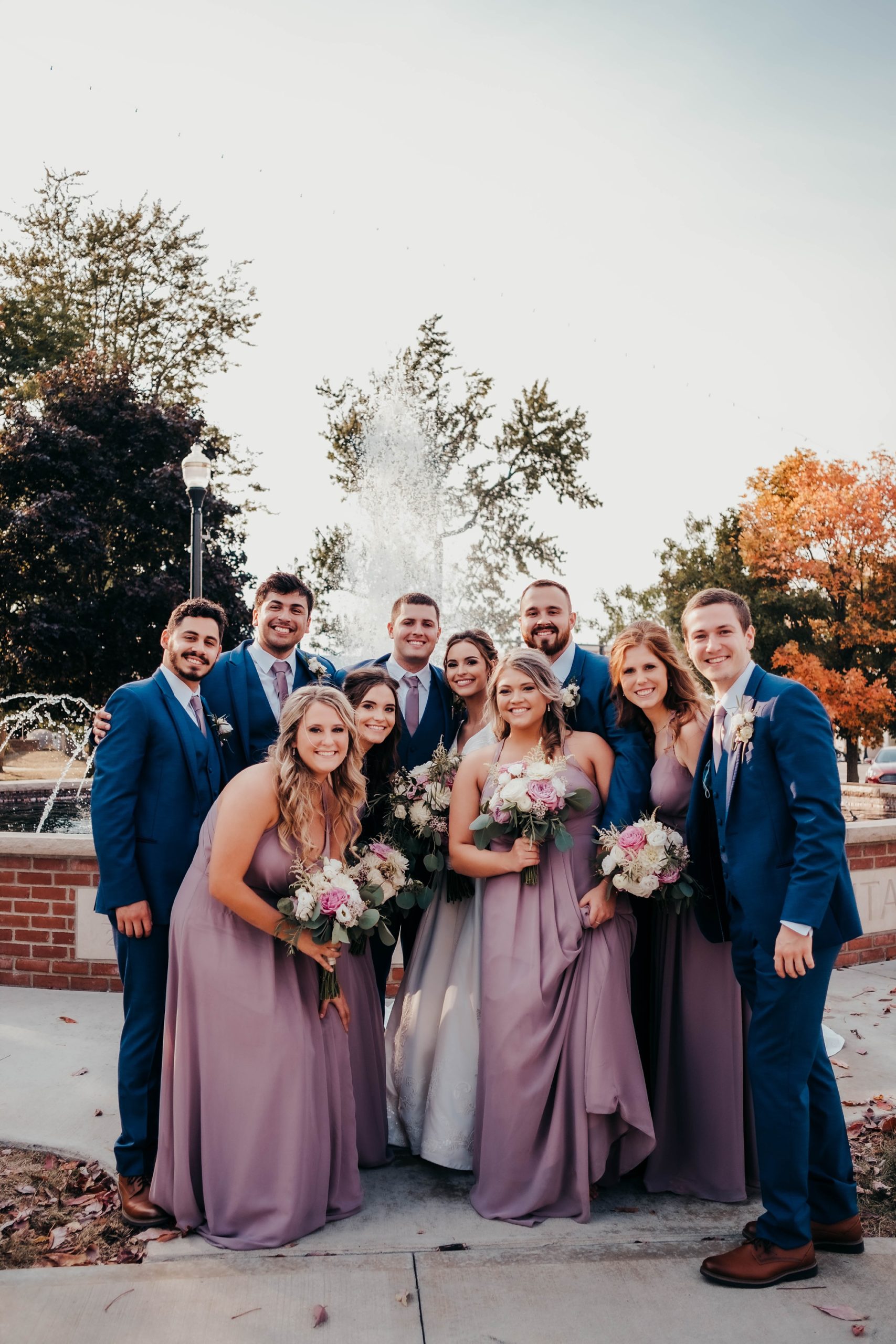 wedding party poses by fountain in Ohio