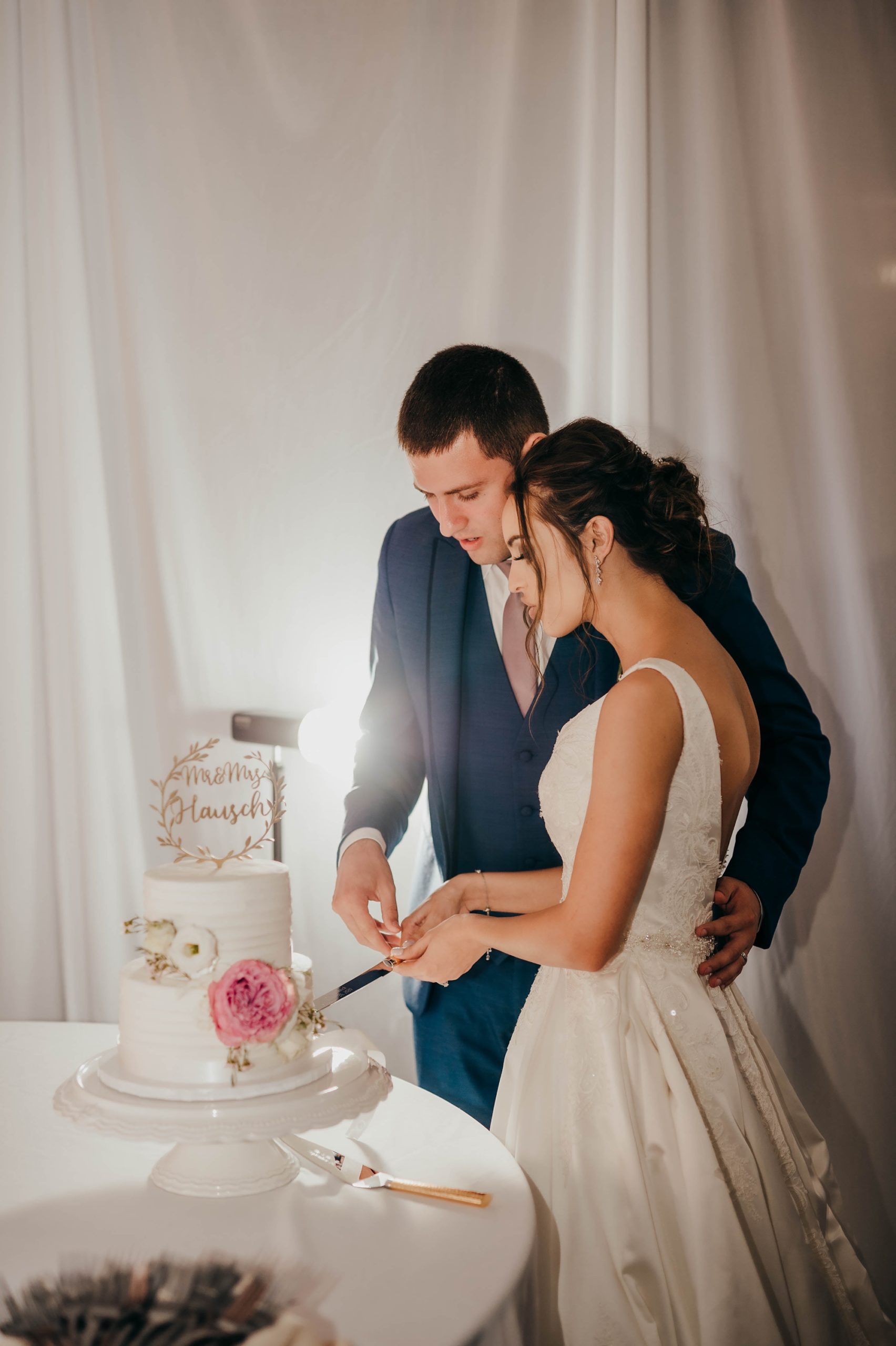bride and groom cut wedding cake during elegant fall wedding reception at the Quality Inn Montpelier OH
